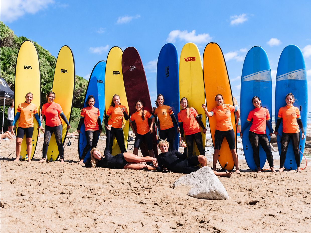Grupo de alumnos con sus tablas en la playa